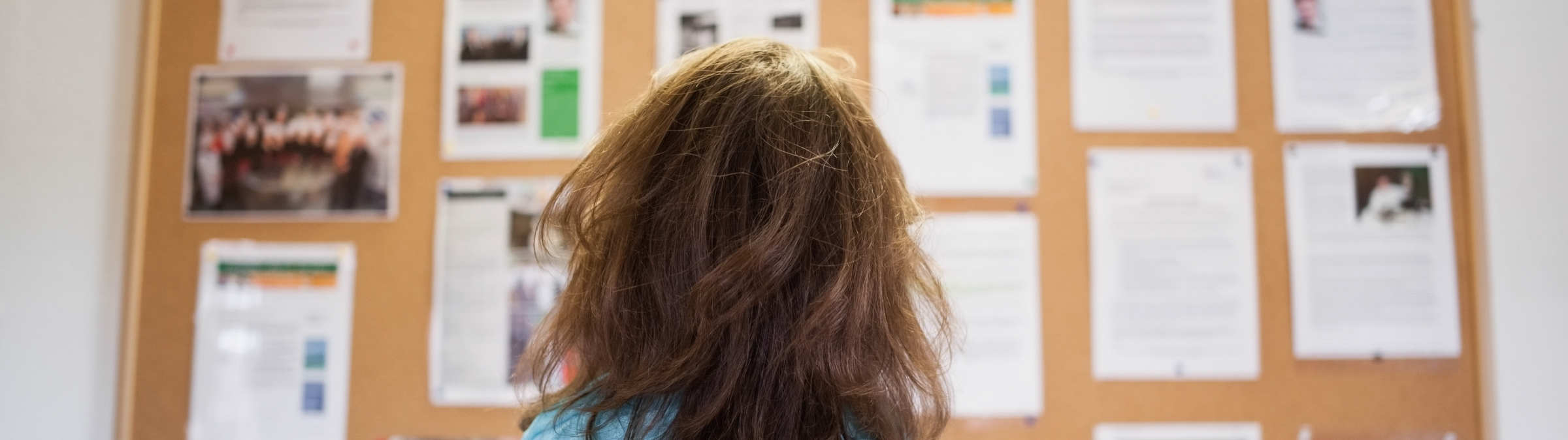 Vrouw die naar een prikbord kijkt.
